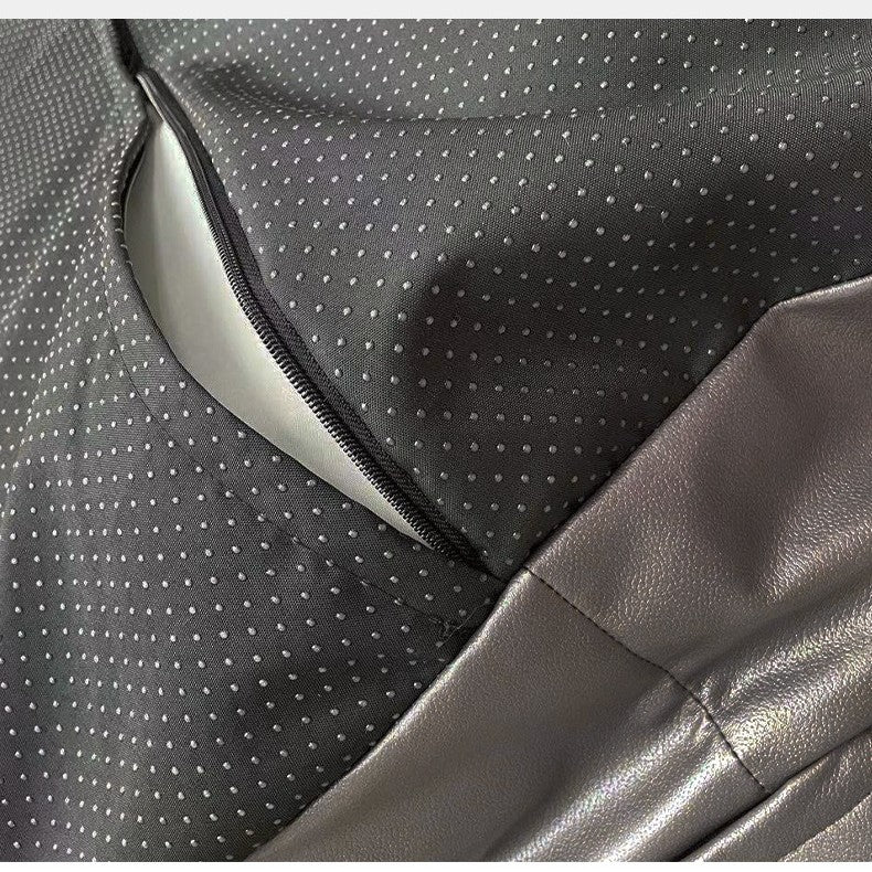 Close-up of a car seat with gray and black patterned fabric and leather.
