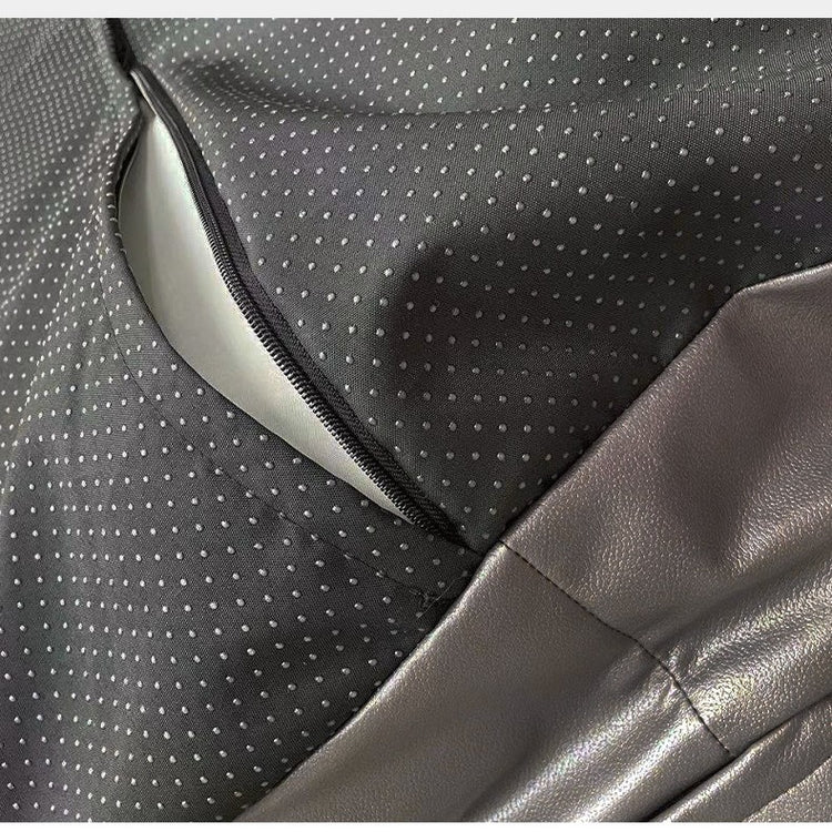 Close-up of a car seat with gray and black patterned fabric and leather.