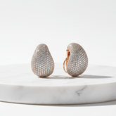 Earrings on marble pedestal